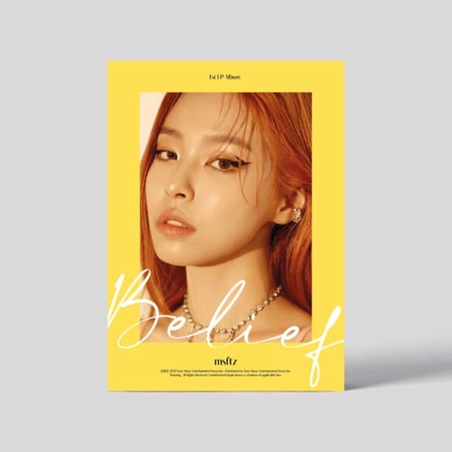 MSFTZ - [Belief] - Album Kpop : pochette avec portrait de la chanteuse, esthétique jaune, marque MSFTZ, fond studio.