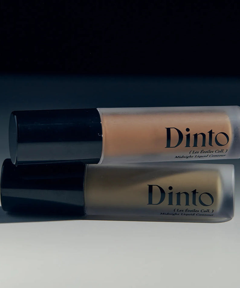 Deux flacons de DINTO Midnight Liquid Contour 2 Types posés sur une surface, éclairage tamisé.