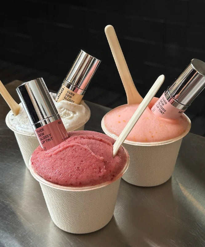 NAMING Overdew Glossy Lip Tint, pack et teintes rosées en pots maquillage, fond noir, visuel beauté produit