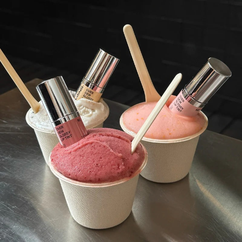 NAMING Overdew Glossy Lip Tint, pack et teintes rosées en pots maquillage, fond noir, visuel beauté produit