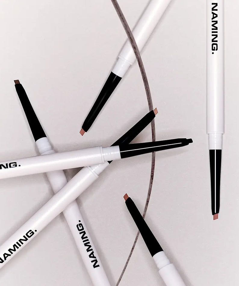 NAMING Pencil Slim Liner, stylos eyeliner noir sur fond blanc et marron, gros plan des produits NAMING.