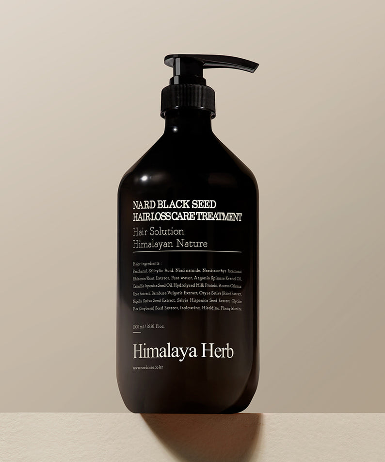 Décris l'image en français : NARD Black Seed Hair Loss Treatment 1000ml de marque NARD, flacon noir pompe, fond clair.