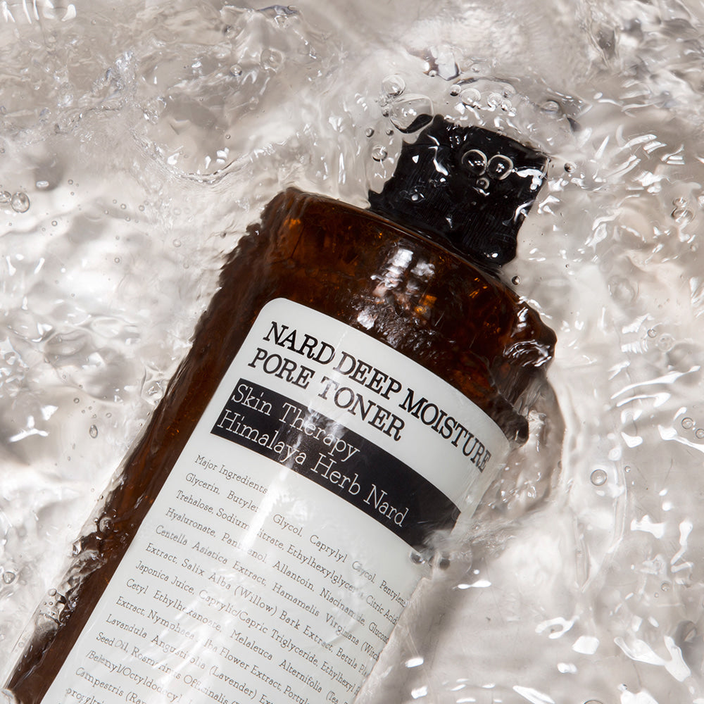 NARD Deep Moisture Pore Toner 500ml de NARD, bouteille sur fond d’éclaboussures d’eau, contexte beauté skincare.