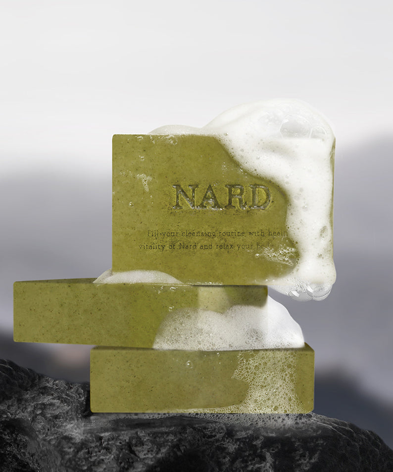 Décris l'image en français : NARD Eoseongcho Soap 100g x 2, marque NARD, savons verts sur fond sombre et blanc.