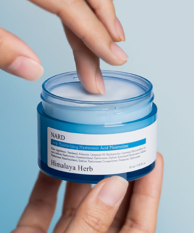 NARD Low Molecular Deep Moisture Hyaluronic Acid Cream 50ml : pot de crème d’hydratation, mains tenant le produit sur fond bleu.
