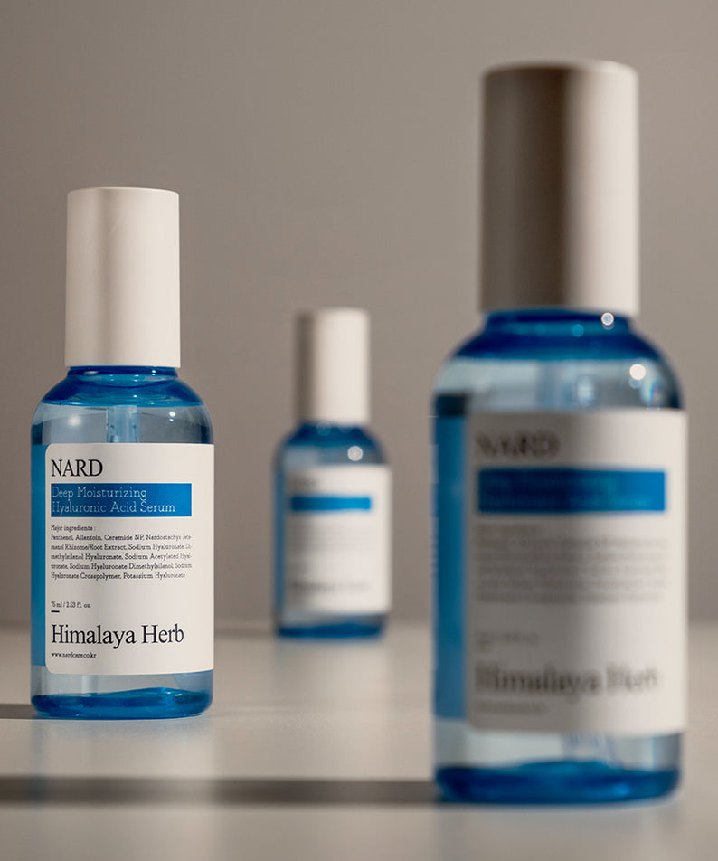 NARD Low Molecular Deep Moisture Hyaluronic Acid Serum 75ml, flacons bleus NARD sur table, contexte beauté en studio