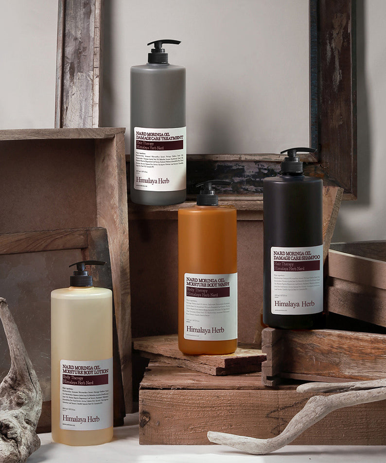 NARD Moringa Oil Damage Care Treatment 1500ml de la marque NARD, flacons sur socle bois et pierres, ambiance spa