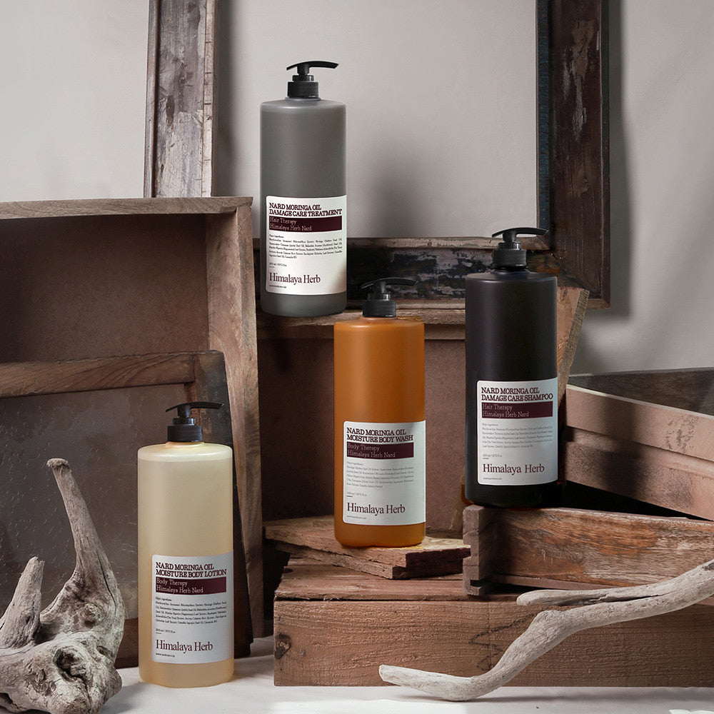 NARD Moringa Oil Damage Care Treatment 1500ml de la marque NARD, flacons sur socle bois et pierres, ambiance spa