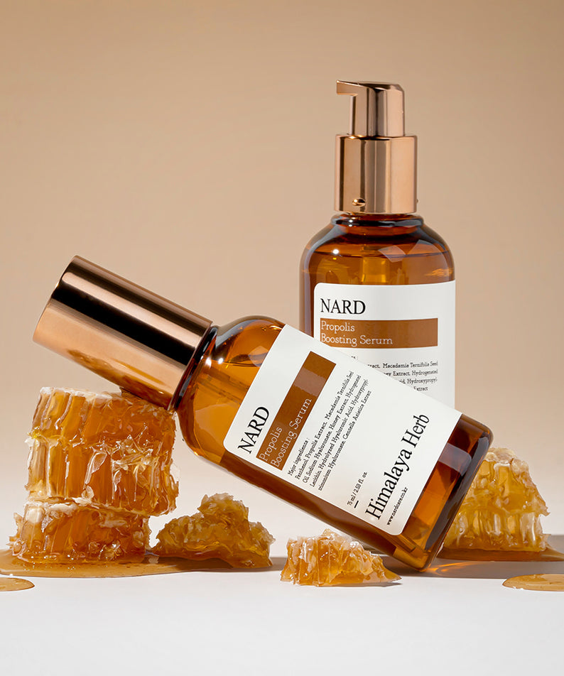 NARD Propolis Boosting Serum 75ml de NARD, flacon doré sur fond beige avec éclats de propolis, studio