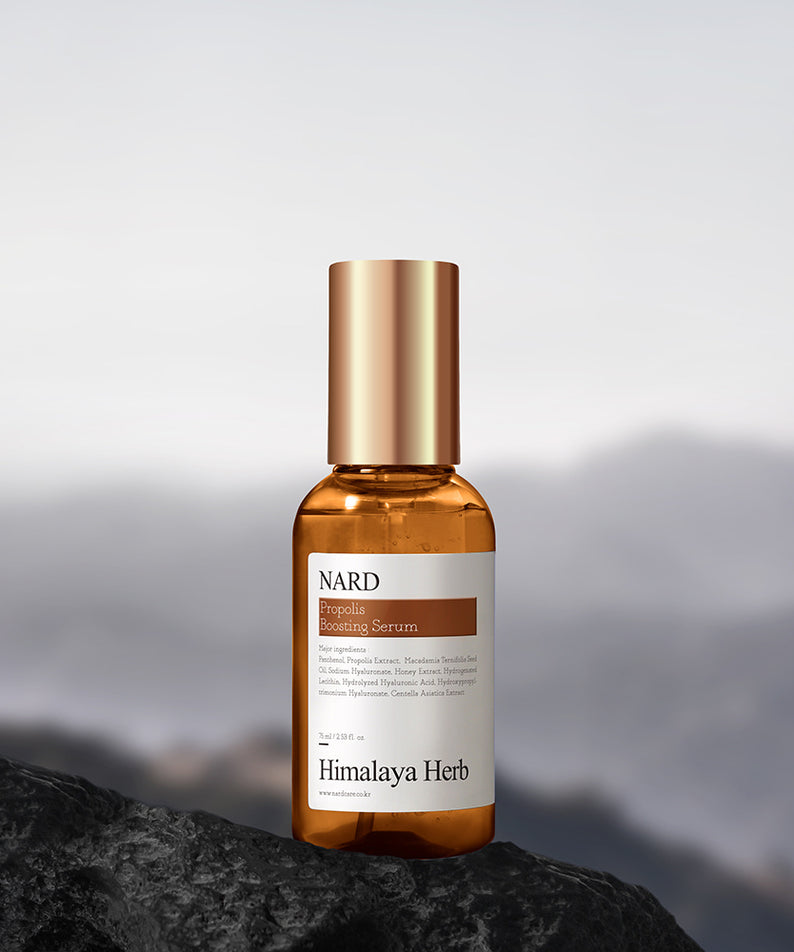 NARD Propolis Boosting Serum 75ml de NARD, flacon sur rocher, ambiance montagne, sérum visage doré.