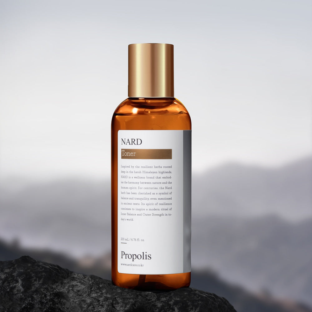 NARD Propolis Infusing Toner 200ml de NARD, flacon ambré sur roche avec fond de montagne, contexte skincare