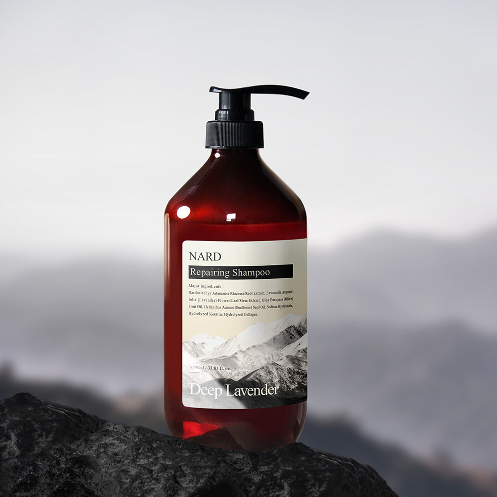 NARD Repairing Shampoo 1500ml de la marque NARD, flacon pompe sur rocher avec montagnes en arrière-plan, ambiance spa.