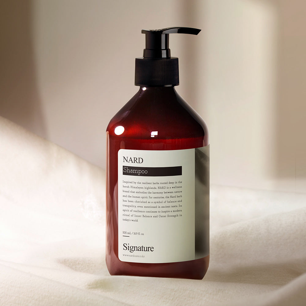 NARD Signature Shampoo 500ml, flacon NARD rouge sur fond crème, pompe noire, photo produit en studio