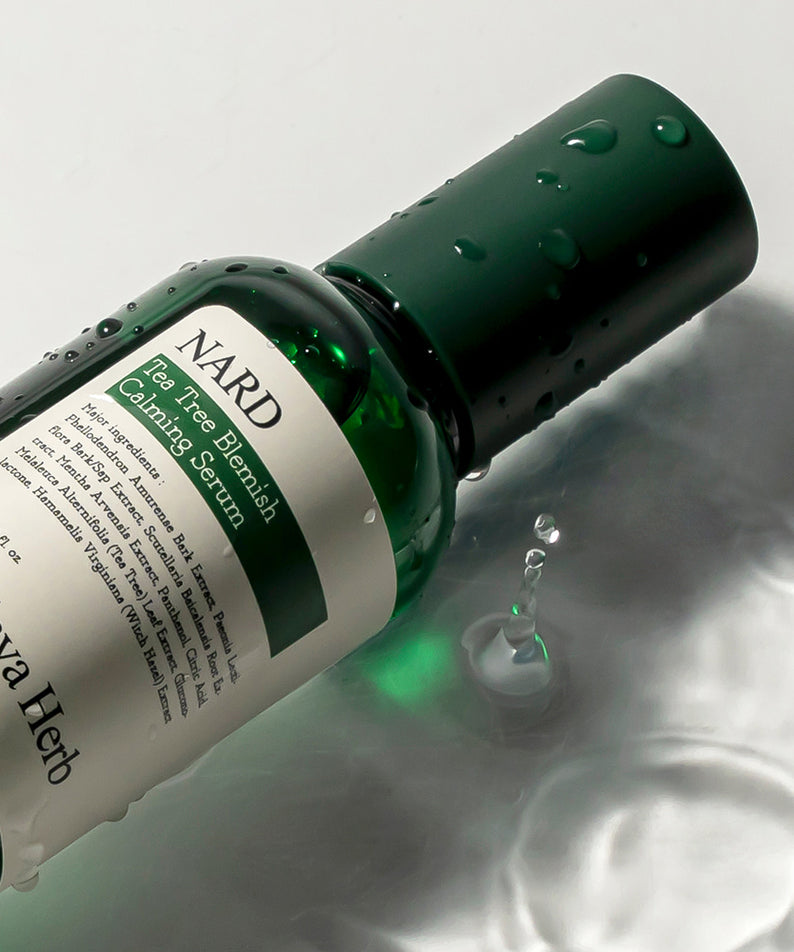 NARD Tea Tree Blemish Soothing Serum 75ml, sérum NARD au tea tree, flacon vert sur fond blanc, gouttes et reflets.