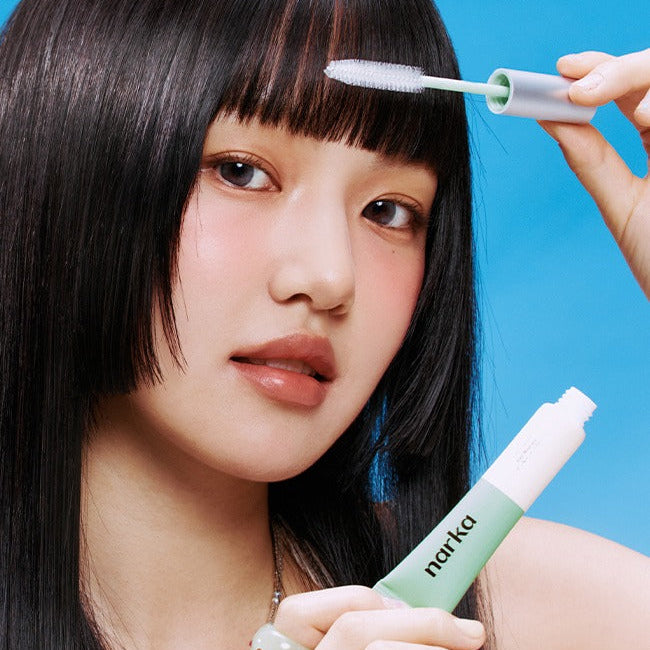 NARKA Fresh Sebum Hair Mascara NARKA : application sur les cheveux par une main, fond bleu, produit en évidence.