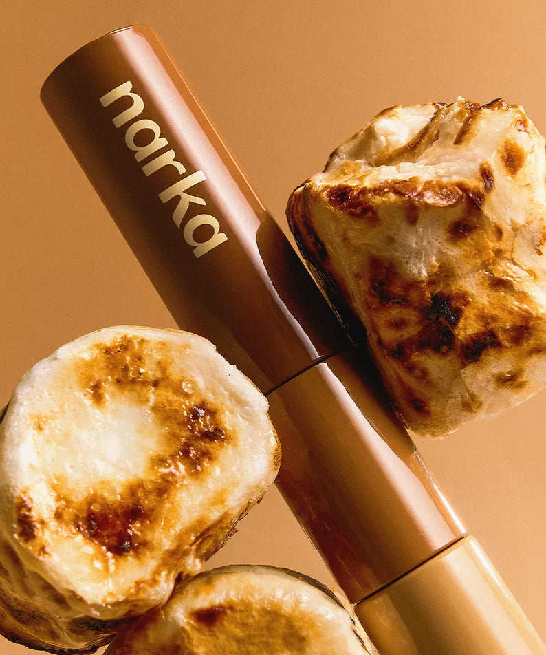 NARKA Hype Fit Hair Mascara [Winter Edition] de marque NARKA, flacon beige sur fond orange, mèche cheveux style hiver.
