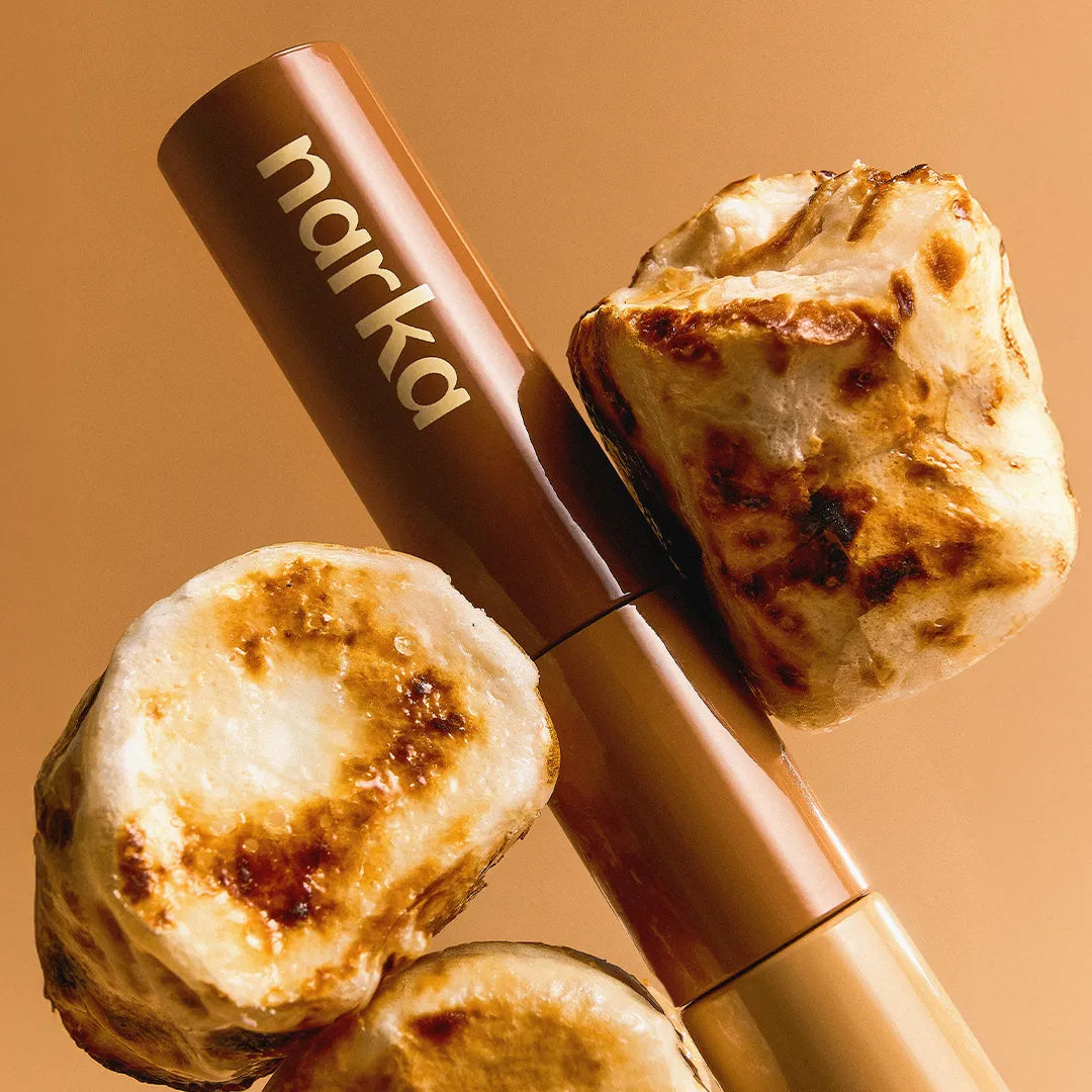 NARKA Hype Fit Hair Mascara [Winter Edition] de marque NARKA, flacon beige sur fond orange, mèche cheveux style hiver.