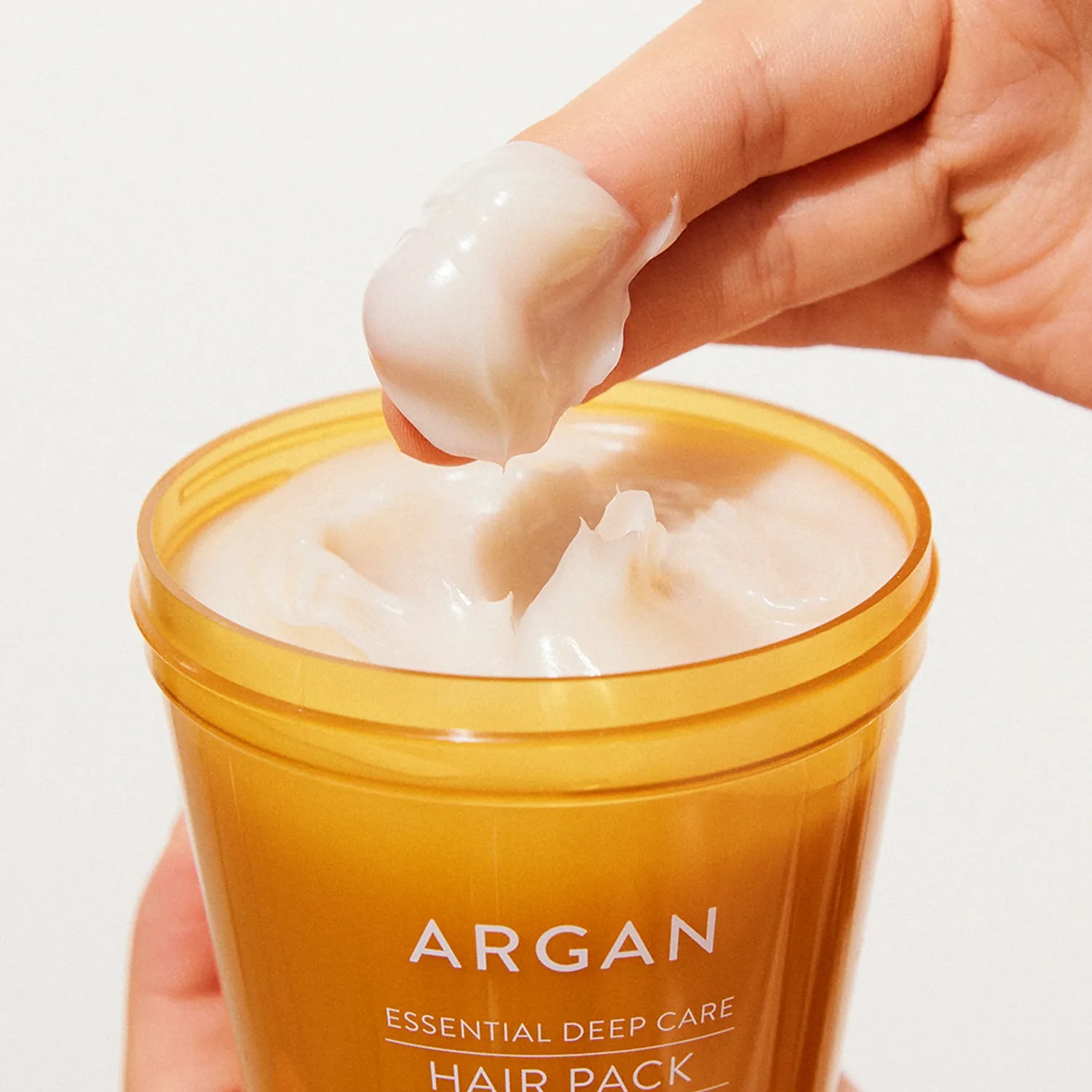 NATURE REPUBLIC Essential Deep Care Hair Pack 470ml, pot d’argan ouvert, main appliquant la crème, gros plan sur le produit