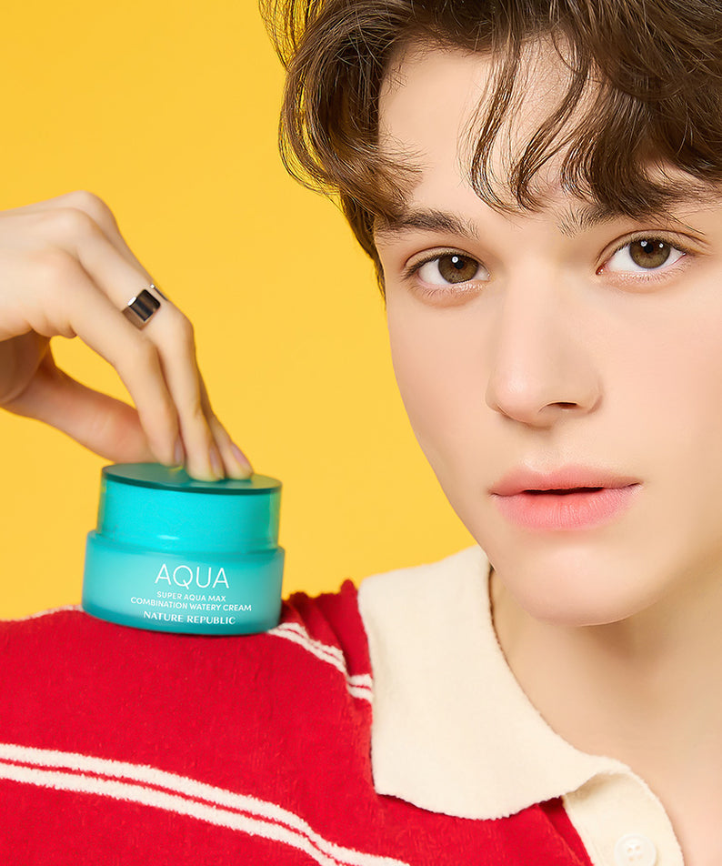 Jeune homme tenant le NATURE REPUBLIC Super Aqua Max Combination Moisture Cream 80ml, hydratant sur fond jaune.