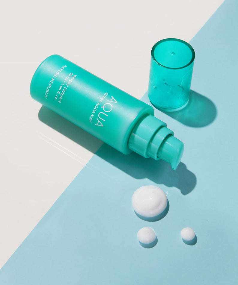 Flacon de NATURE REPUBLIC Super Aqua Max Moisture Essece 50ml sur fond bleu avec gouttelettes de produit.