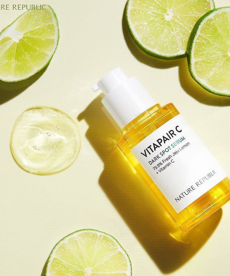 Sérum éclaircissant NATURE REPUBLIC Vitapair C SPot Serum 45ml sur fond de citrons verts, éclairant la peau avec vitamine C.