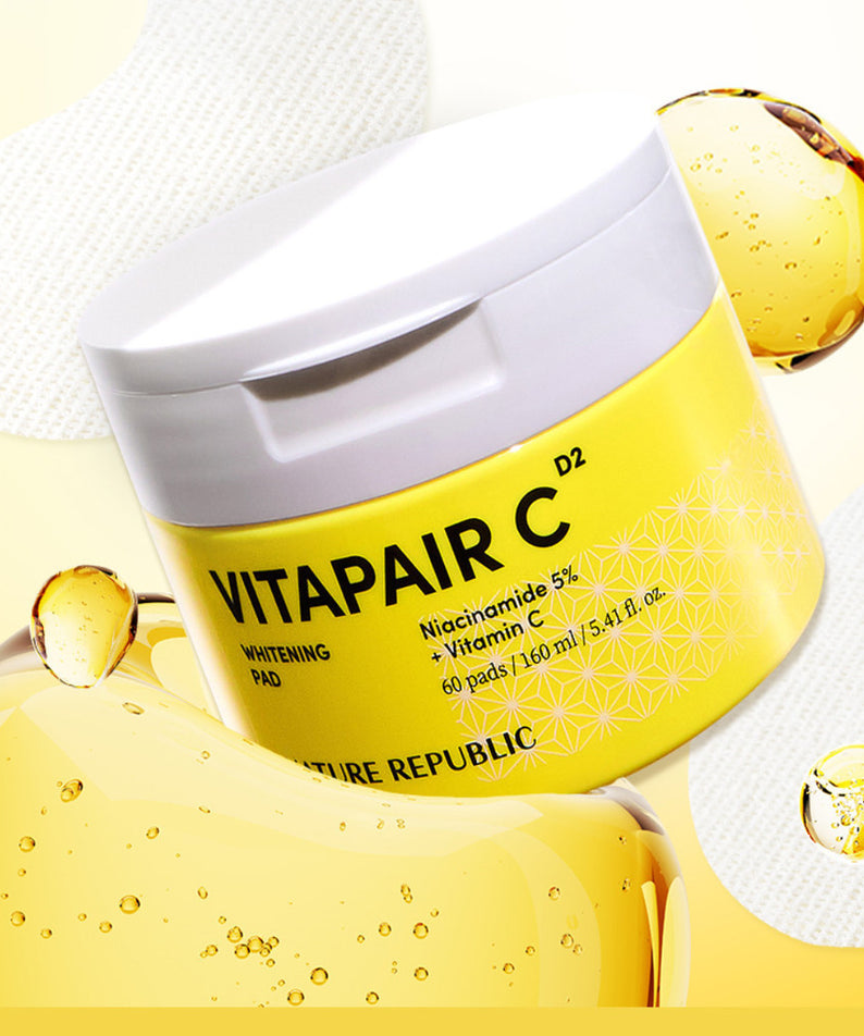 Pot de 160ml de NATURE REPUBLIC Vitapair C Whitenning Pads sur fond jaune avec éclaboussures de sérum et pads visibles.