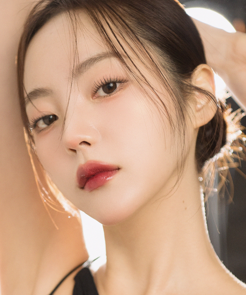 Femme portant QUA-T The Glass Tattoo Tint, maquillage subtil et allure chic en éclairage doux.