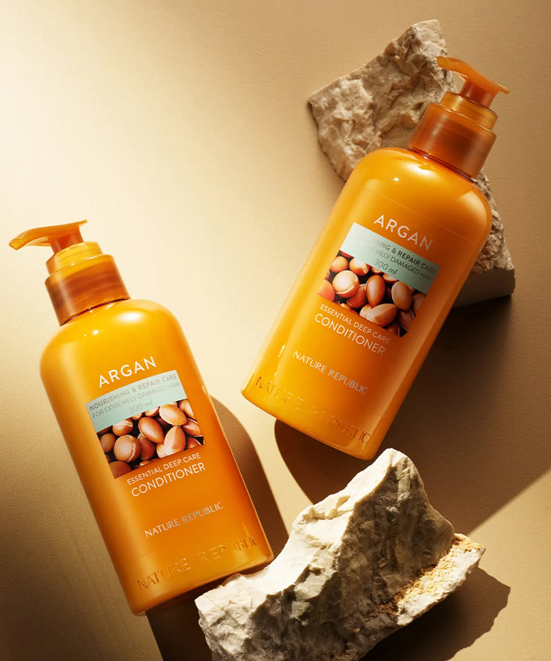 NATURE REPUBLIC Essential Deep Care Conditioner for Damaged Hair 300ml sur fond naturel en pierres et lumière dorée.