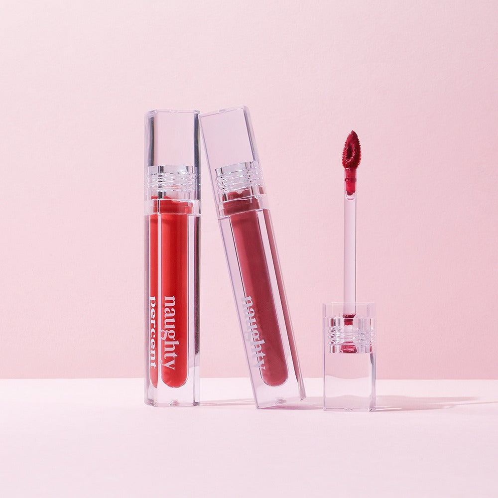 NAUGHTY PERCENT Matte Bloom Tint de la marque Naughty, sur fond rose : flacons et applicateur maquillage mat.