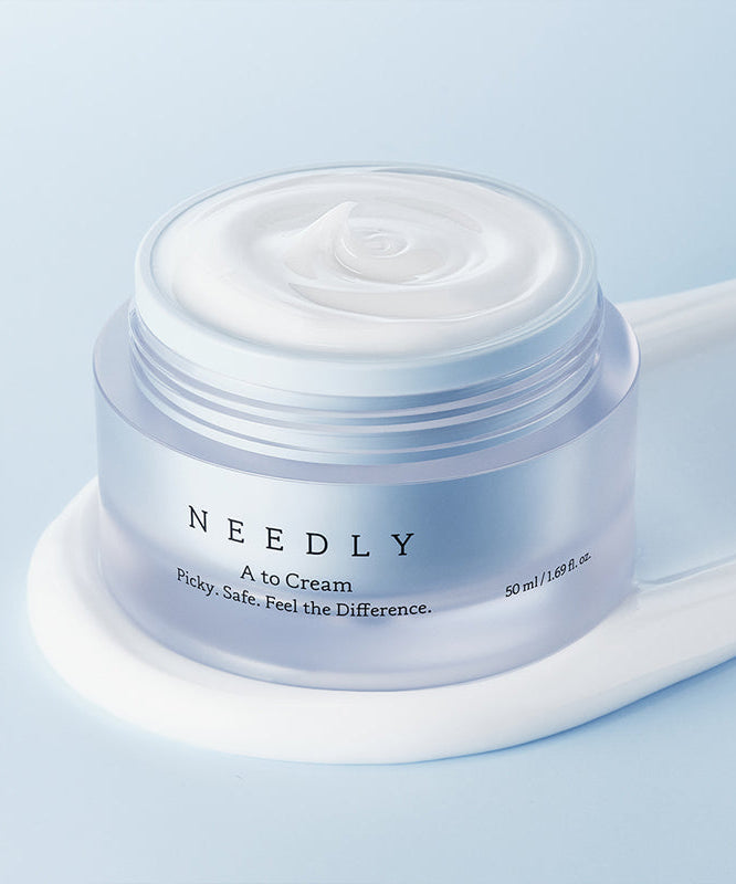 NEEDLY A to Cream 50ml de la marque NEEDLY, pot blanc sur fond bleu, crème lisse en contexte beauté.