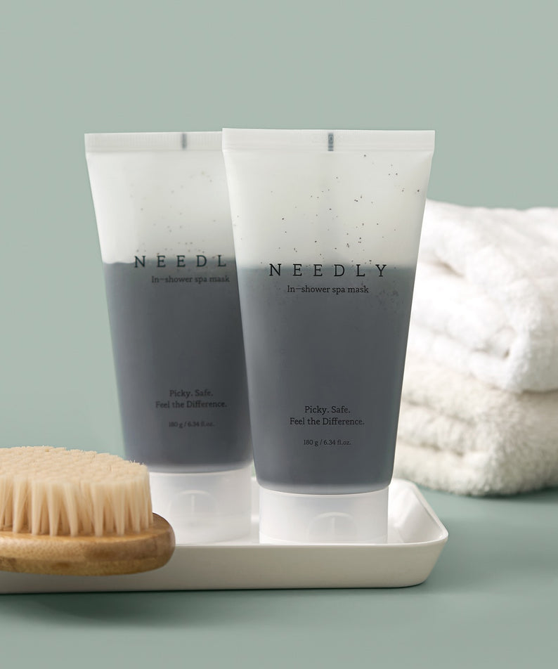 NEEDLY Ishower Spa Mask 180g, tubes de la marque NEEDLY sur plateau avec brosse et serviette, ambiance spa