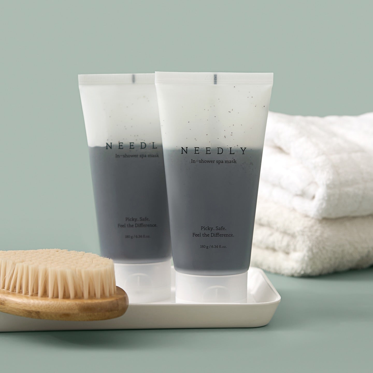 NEEDLY Ishower Spa Mask 180g, tubes de la marque NEEDLY sur plateau avec brosse et serviette, ambiance spa