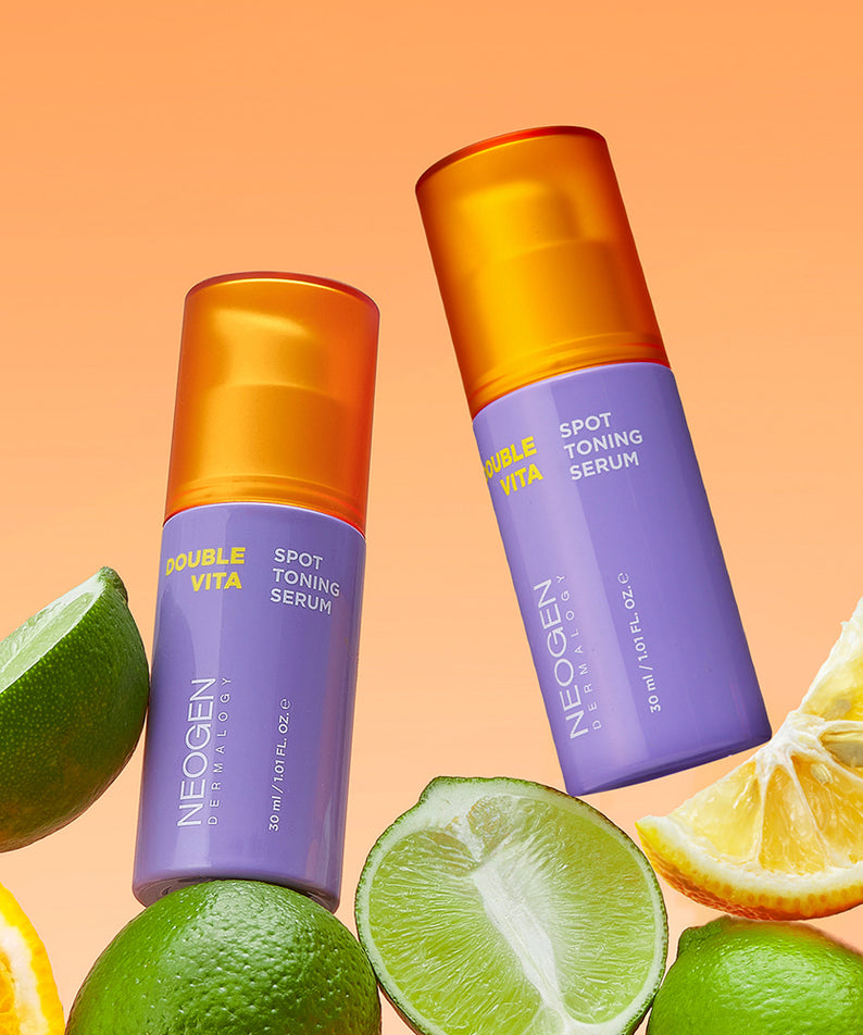 Décris l'image en français mentionnant NEOGEN Double Vita Spot Toning Serum 30ml, la marque et des agrumes sur fond orange.