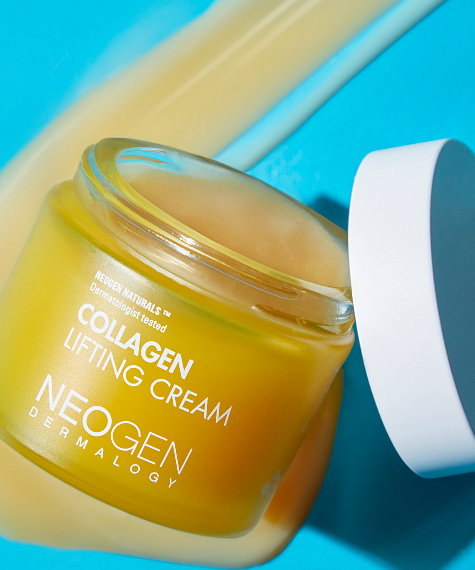 NEOGEN Collagen Lifting Cream 70ml en pot ouvert sur fond coloré, produit anti-âge pour une peau raffermie et hydratée.