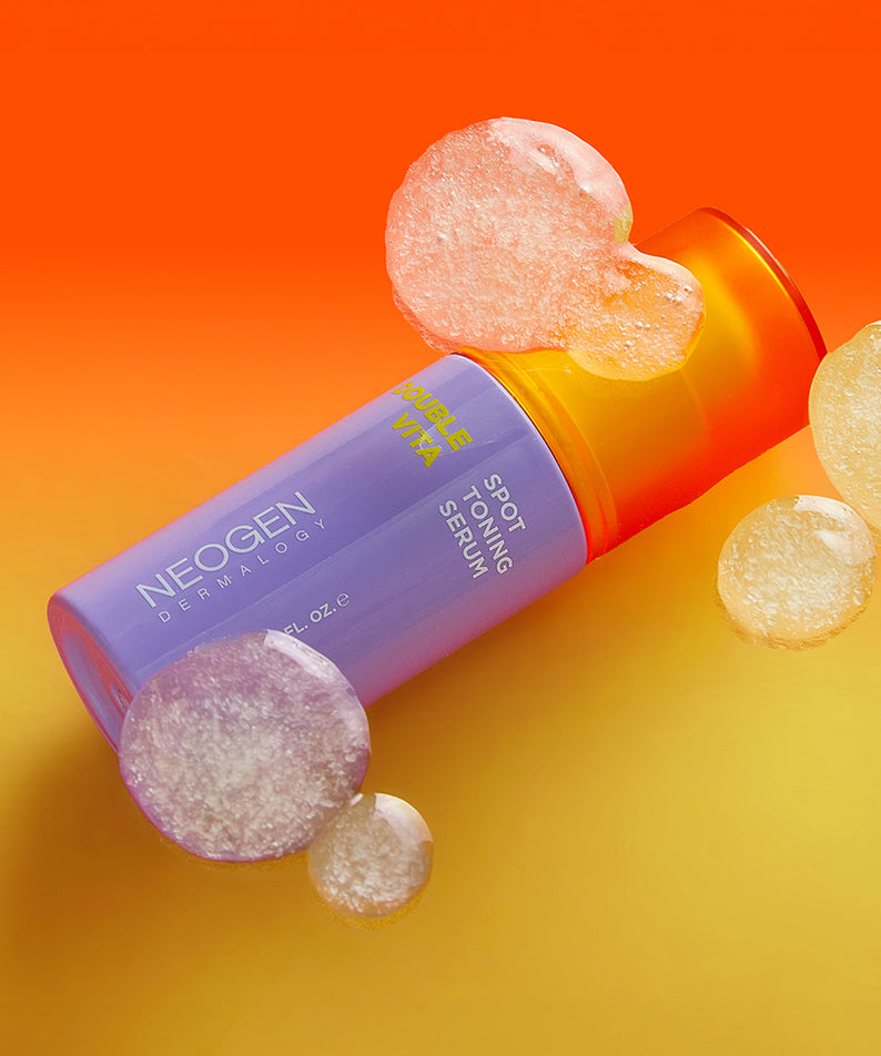Flacon de 30ml de NEOGEN Double Vita Spot Toning Serum sur fond coloré vibrant avec bulles.