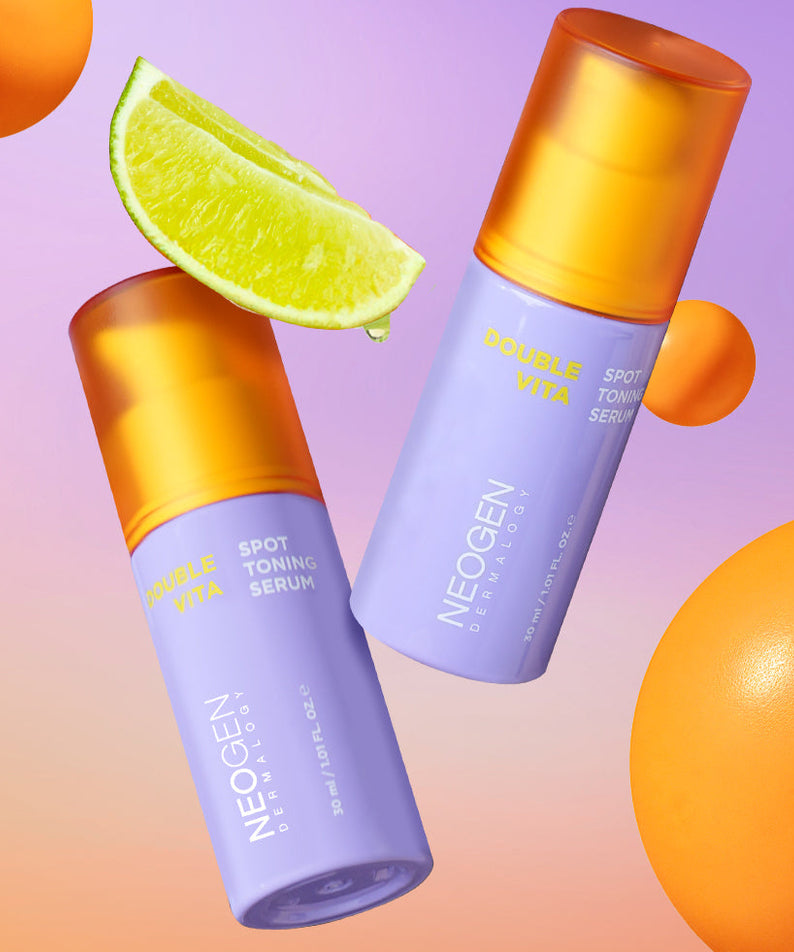 Flacons de NEOGEN Double Vita Spot Toning Serum 30ml avec agrumes en fond vibrant.