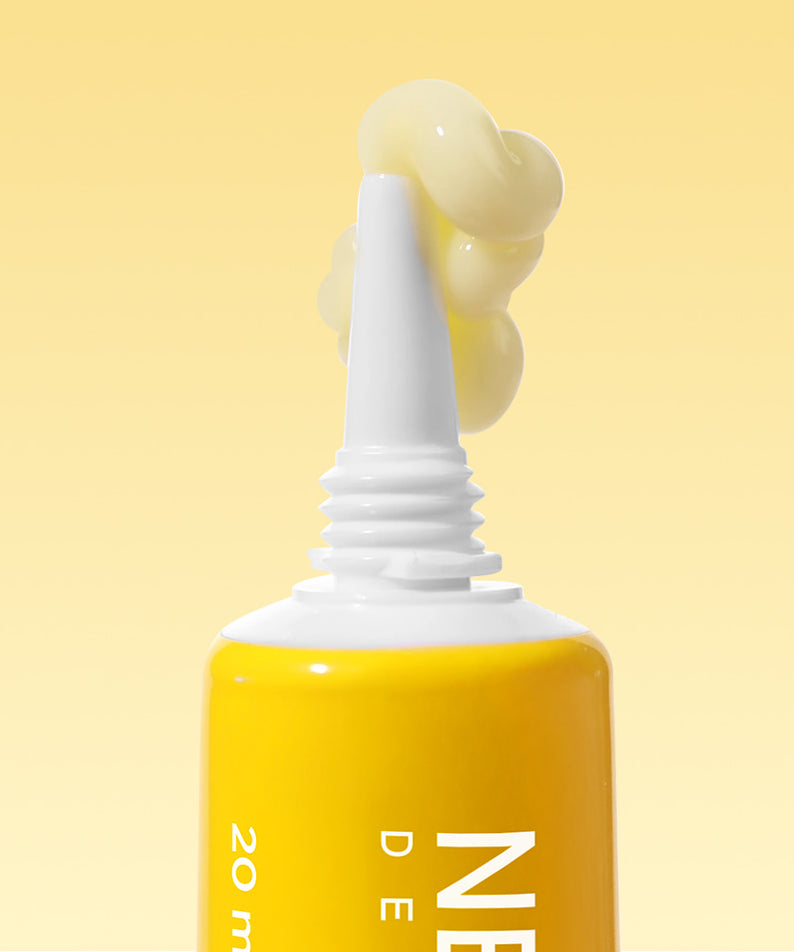 Texture du NEOGEN Next Clear Eye Cream 20ml sur un fond jaune lumineux, mettant en avant la couleur riche et crémeuse du produit.