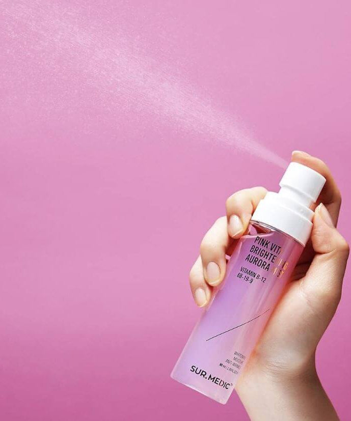 Flacon de NEOGEN Pink Vita Aurora Mist 115ml pulvérisé sur fond rose, soin visage hydratant de Neogen idéal pour une peau éclatante.