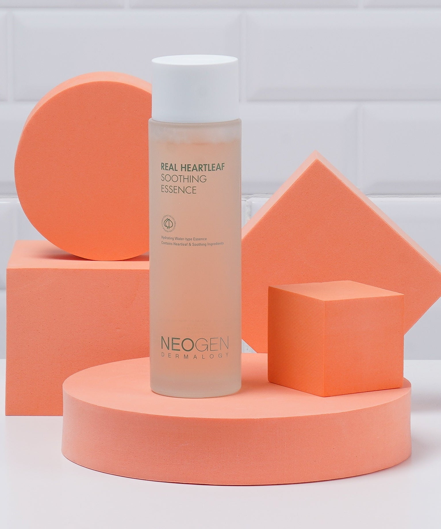 NEOGEN Real Heartleaf Soothing Essence 150ml, bouteille sur fond géométrique orange