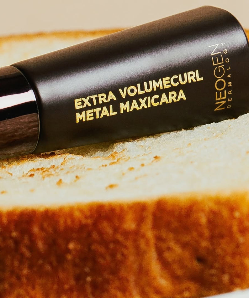 Mascara NEOGEN Volume Curl Matal Mascara Brown 4ml sur une tranche de pain, offrant un volume et une courbe exceptionnelle.