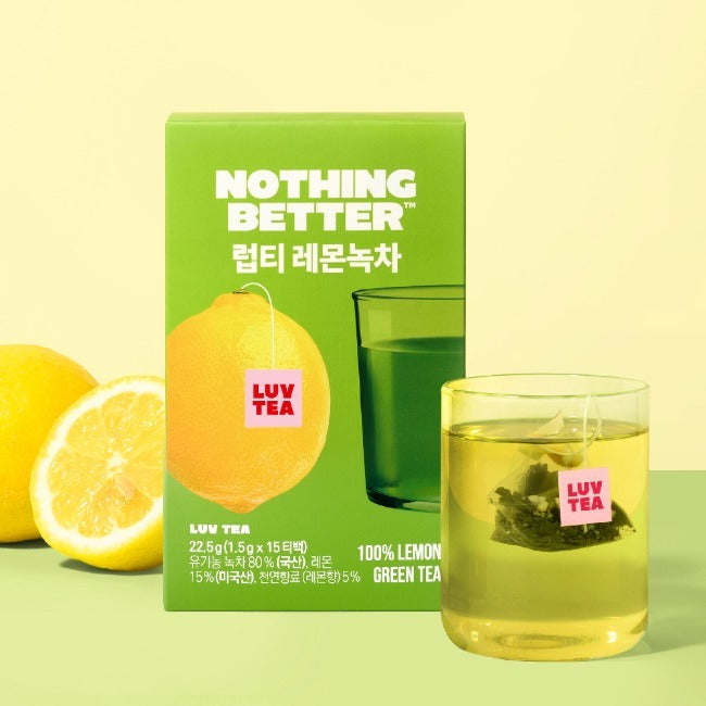 Décris l'image en français : NOTHING BETTER Luv Tea Lemon Green Tea (X15), boîtes vertes, citron, tasse, contexte visuel.