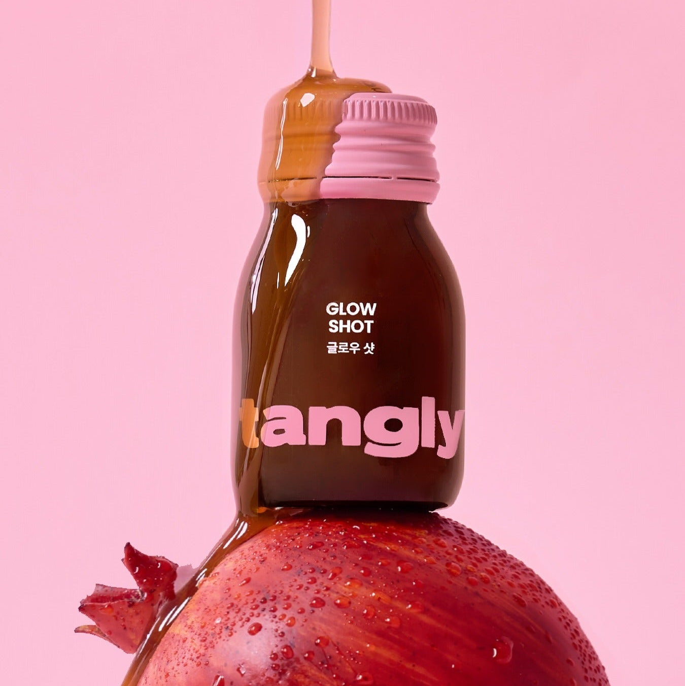 NOTHING BETTER Tangly Glow Shot 7 Bottles, la marque Tangly, sur une fraise juteuse, fond rose, mise en scène.