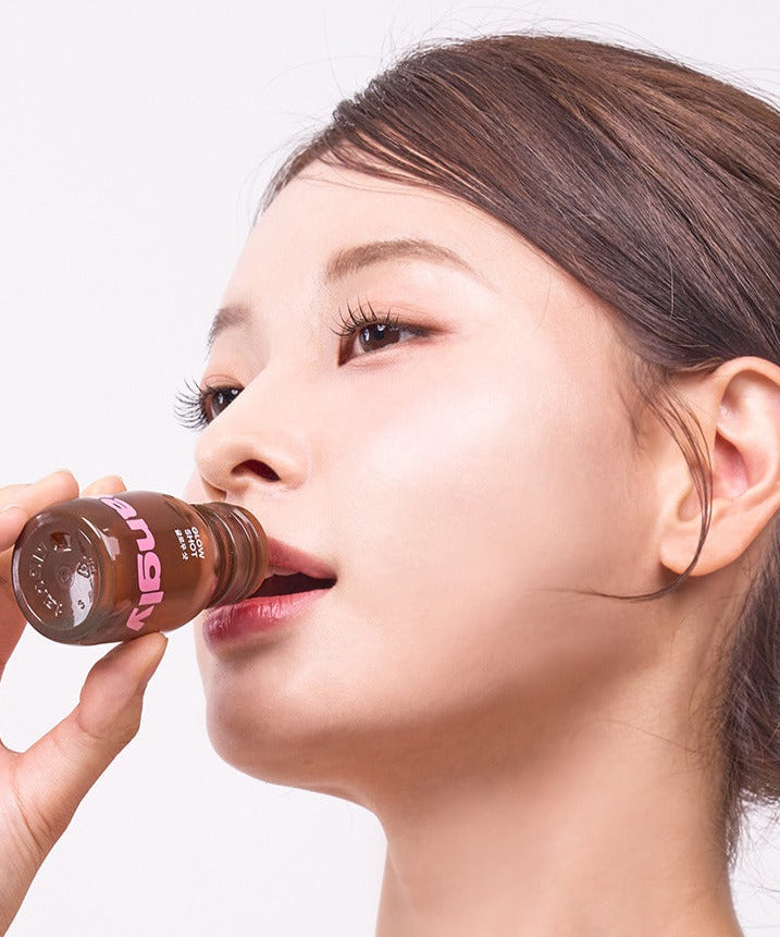 Rafraîchissante NOTHING BETTER Tangly Glow Shot 7 Bottles consommée par une femme. Optimisez votre éclat avec ce boost délicieux.