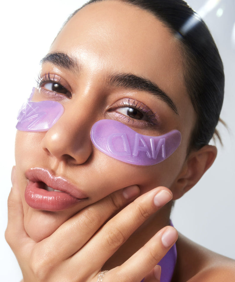 NUMBUZIN No. 9 NAD Collagen Overnight Selfie Patch : femme applique des patches violets visage, gros plan en lumière douce