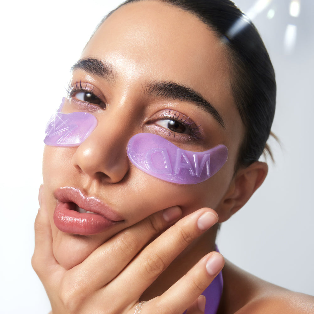 NUMBUZIN No. 9 NAD Collagen Overnight Selfie Patch : femme applique des patches violets visage, gros plan en lumière douce
