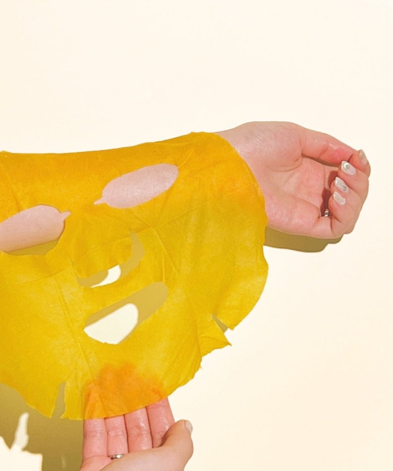NUMBUZIN No.5 Vitamin Spotlight Sheets Mask, marque NUMBUZIN, masque en feuille jaune sur mains avec taches de vitamines