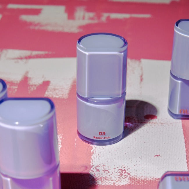 NUSE Care Lipstick de NUSE, pack violet sur fond maquillage rouge et blanc, gros plan produit cosmétique