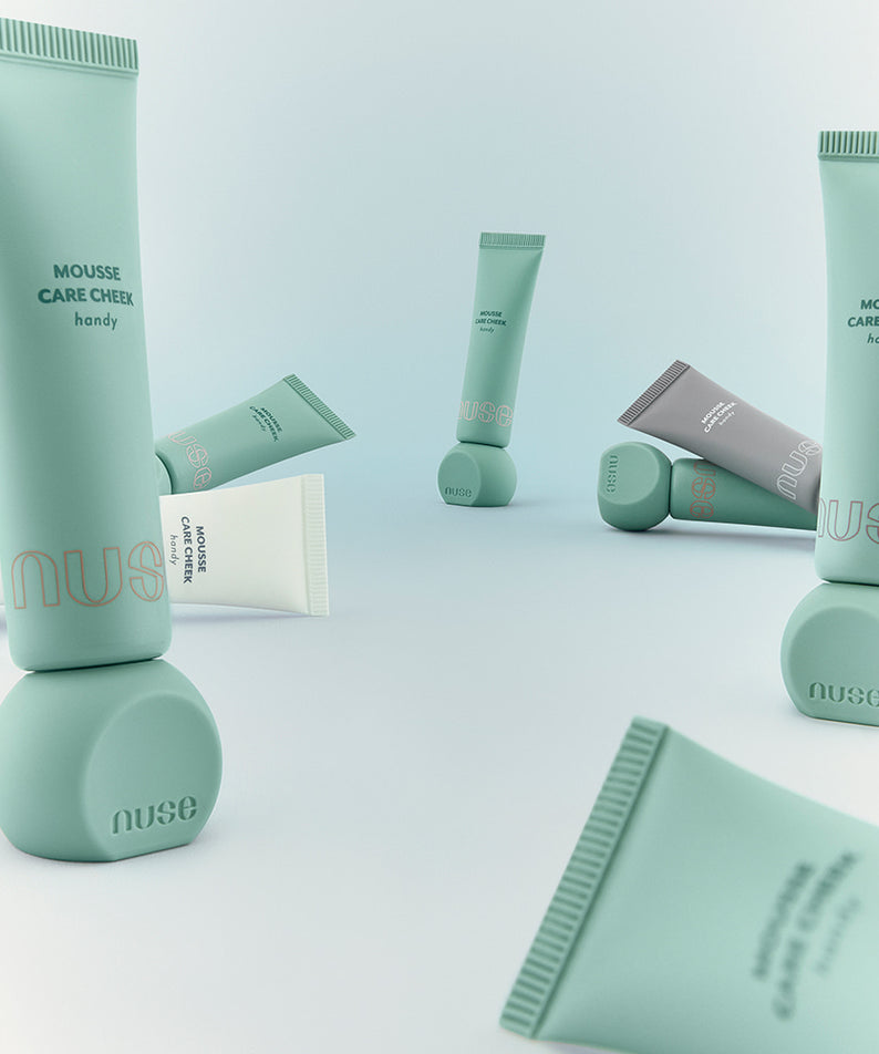 Produits de maquillage NUSE Mousse Care Cheek Handy sur fond blanc élégamment disposés