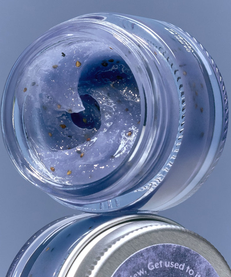 NUSE Seed Care Lip Scrub, pot ouvert avec gommage bleu et graines, sur fond bleu, marque NUSE