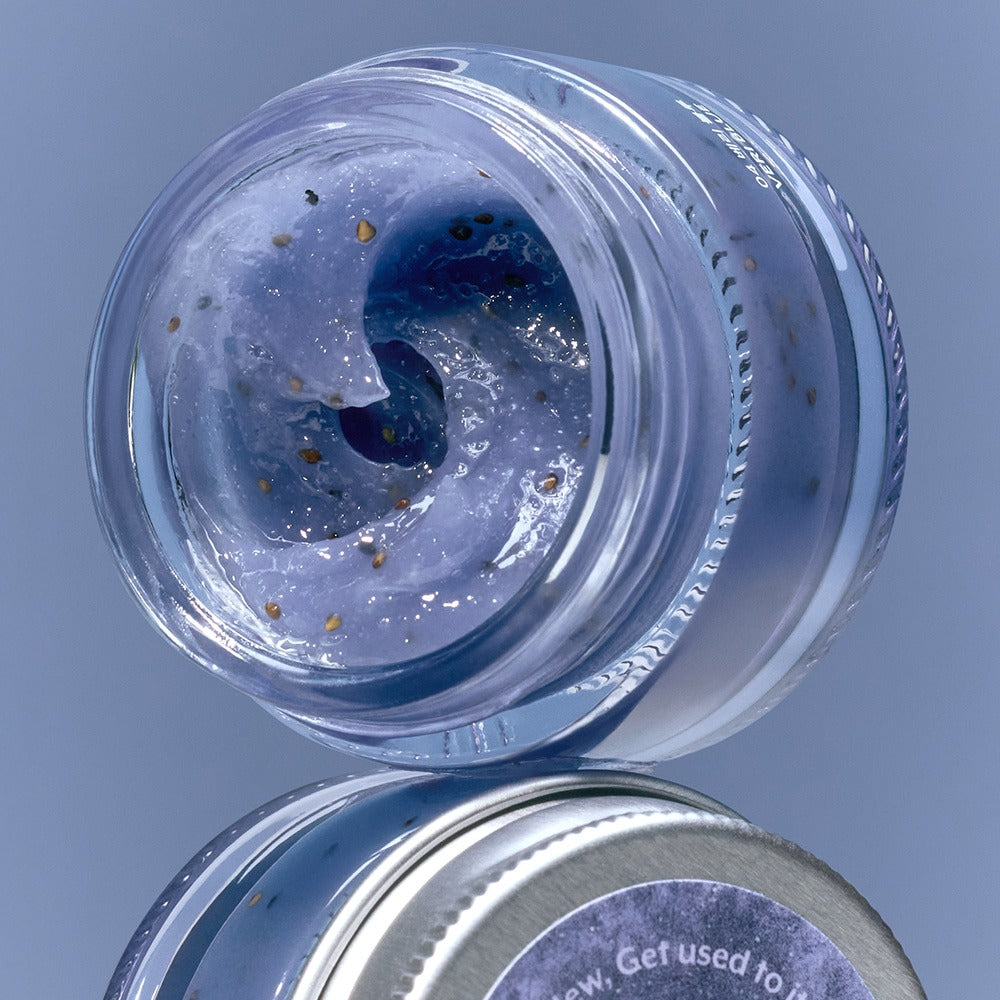 NUSE Seed Care Lip Scrub, pot ouvert avec gommage bleu et graines, sur fond bleu, marque NUSE